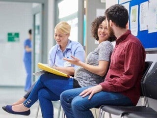 Plano de parto Gestante conversando com médico e acompanhante em hospital