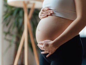 Close de uma mulher grávida acariciando a barriga. Contrações na gravidez.