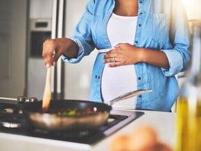 Mulher grávida celíaca na cozinha preparando comida sem glúten