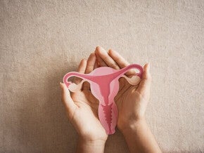 Mulher segurando útero, sistema reprodutor feminino, saúde da mulher, SOP, conceito ginecológico.