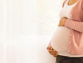 Pessoa grávida tocando a barriga durante a gravidez