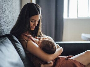 Mãe amamentando o bebê com frequência para aumentar a produção de leite materno