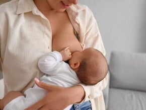 Uma mãe amamentando seu bebê, representando a importância da dieta de exclusão de proteína do leite de vaca para o bebê alérgico que está em aleitamento materno.