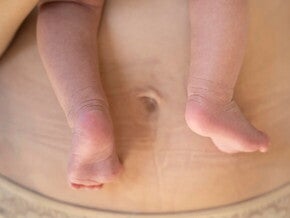 Mãe com recém-nascido no colo vestindo uma calcinha pós-parto Mãe com recém-nascido no colo vestindo uma calcinha pós-parto
