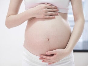 Mulher grávida com as mãos sobre a barriga Mulher grávida com as mãos sobre a barriga