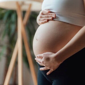 Close de uma mulher grávida acariciando a barriga. Contrações na gravidez.