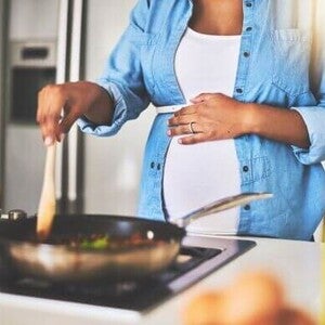 Mulher grávida celíaca na cozinha preparando comida sem glúten