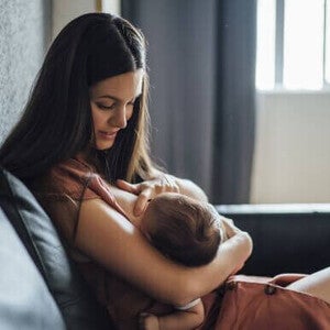 Mãe amamentando o bebê com frequência para aumentar a produção de leite materno