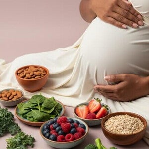 Gestante com mãos na barriga e alimentos representando macronutrientes e micronutrientes.