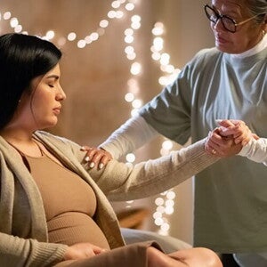Doula segurando a mão de uma mulher grávida em trabalho de parto, demonstrando apoio e conexão Doula segurando a mão de uma mulher grávida em trabalho de parto, demonstrando apoio e conexão