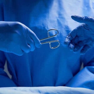 imagem de duas mãos com luvas cirúrgicas repassando um fórceps imagem de duas mãos com luvas cirúrgicas repassando um fórceps