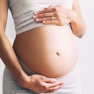 Imagem de mulher com as mãos na barriga para representar eritroblastose fetal. Imagem de mulher com as mãos na barriga para representar eritroblastose fetal.