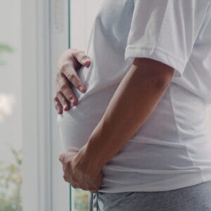 imagem de uma mulher grávida usando uma camiseta branco, com maior foco na barriga imagem de uma mulher grávida usando uma camiseta branco, com maior foco na barriga