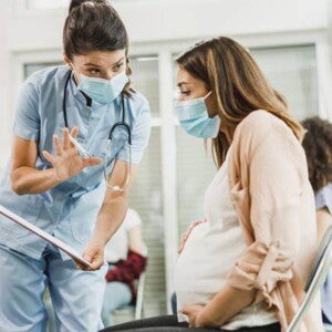 médica dialogando com uma gestante e mostrando uma prancheta médica dialogando com uma gestante e mostrando uma prancheta