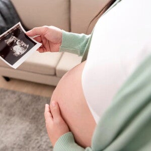 mulher segura barriga com receio de perda de líquido amniótico mulher segura barriga com receio de perda de líquido amniótico