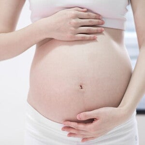 Mulher grávida com as mãos sobre a barriga Mulher grávida com as mãos sobre a barriga