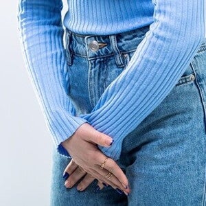mulher usando calça jeans com as mãos posicionadas à frente da região íntima feminina mulher usando calça jeans com as mãos posicionadas à frente da região íntima feminina