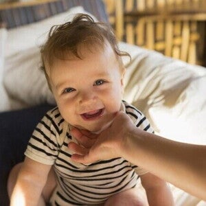 Bebê sorrindo nas mãos da mãe, por Nestlé Baby & Me