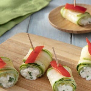 Rolinhos de Abobrinha com Queijo dispostos em tábua de madeira