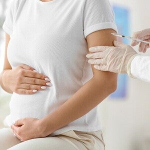 Gestante recebendo vacina no braço durante consulta médica. Gestante recebendo vacina no braço durante consulta médica.