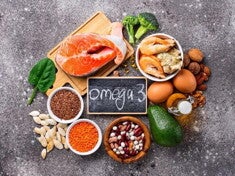 alimentos ricos em ômega 3, como salmão, nozes, sementes e abacate, dispostos sobre uma mesa.