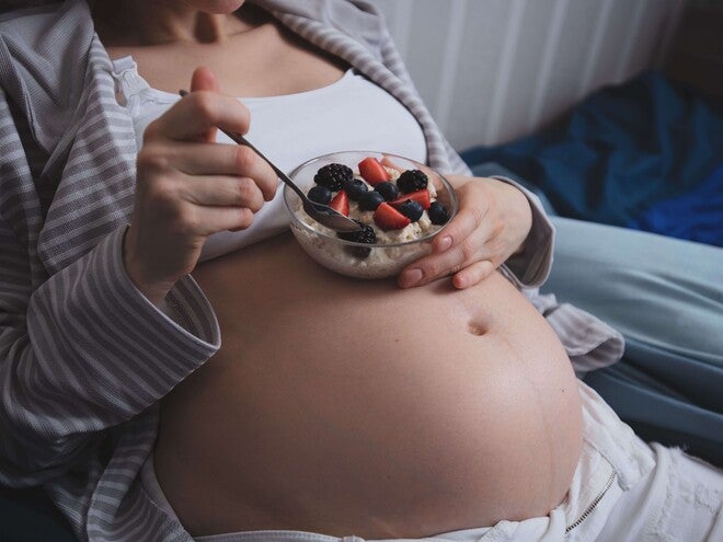 Pessoa grávida escolhendo frutas como parte da alimentação durante a gestação