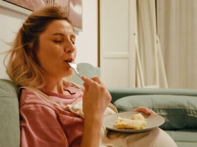 Mulher grávida comendo alimentos gordurosos