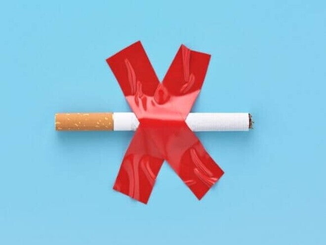Imagem simbólica mostrando um cigarro com um "X" de fita vermelha, representando a importância de parar de fumar na gravidez.
