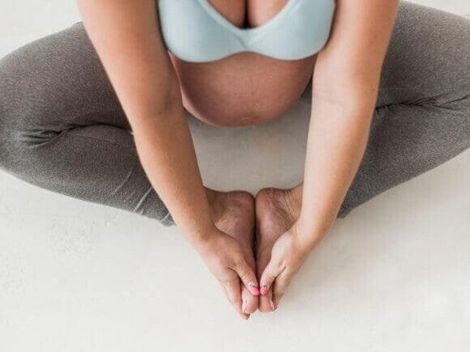 Gestante sentada no chão em posição de relaxamento Gestante sentada no chão em posição de relaxamento