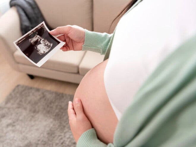 mulher segura barriga com receio de perda de líquido amniótico mulher segura barriga com receio de perda de líquido amniótico