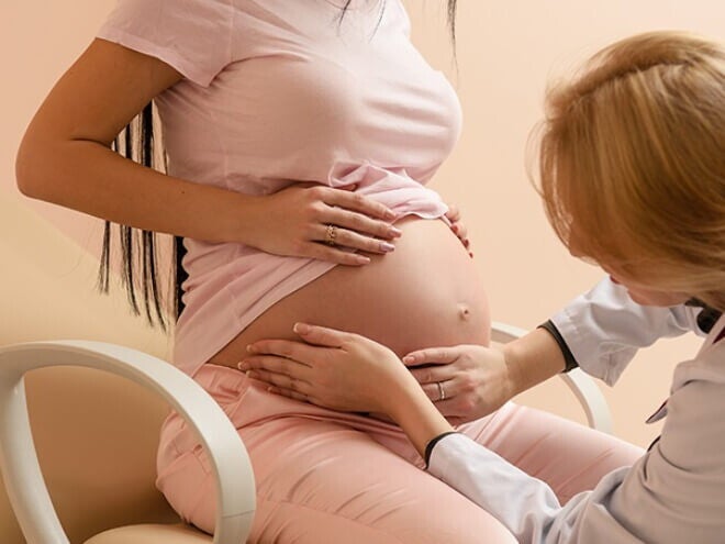 Médica obstetra apalpando a barriga de uma mulher grávida Médica obstetra apalpando a barriga de uma mulher grávida
