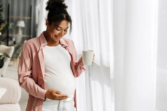 Mujer embarazada tomando té de jengibre para calmar la naúsea