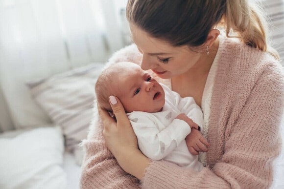 Mamãe segurando seu bebê recém-nascido nos braços