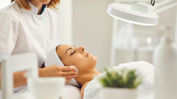 Mulher sendo atendida por profissional de saúde durante um tratamento estético Mulher sendo atendida por profissional de saúde durante um tratamento estético