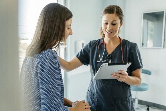 Médico confortando uma mulher ao mostrar o resultado de um teste de infertilidade