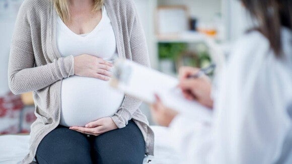 Gestante em consulta médica com a mão sobre a barriga. Gestante em consulta médica com a mão sobre a barriga.