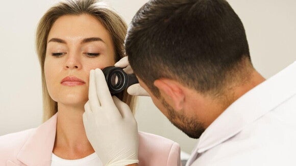 Dermatologista examinando manchas na pele de mulher grávida.