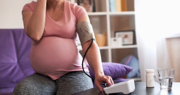 Gestante que faz tratamento para diabetes gestacional usando aparelho para medir pressão em casa. Gestante que faz tratamento para diabetes gestacional usando aparelho para medir pressão em casa.