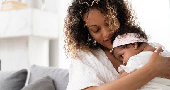 Imagem de uma mãe segurando sua bebê no colo