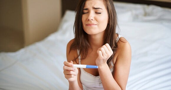 mulher apreensiva segurando teste de gravidez mulher apreensiva segurando teste de gravidez