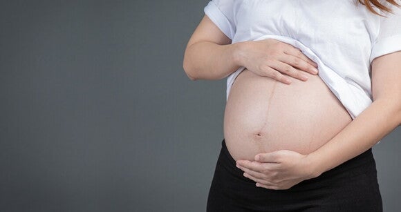 Mulher grávida com as mãos sobre a barriga Mulher grávida com as mãos sobre a barriga