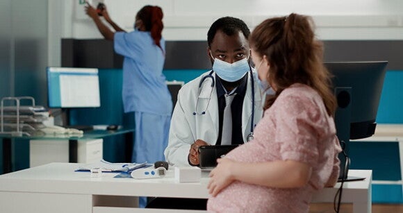 Mulher grávida em acompanhamento pré-natal em consultório médico Mulher grávida em acompanhamento pré-natal em consultório médico
